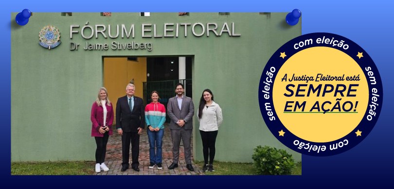 Fotografia em que aparecem três mulheres e dois homens posando em pé em frente à fachada do Fóru...
