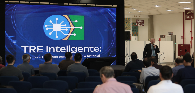 Fotografia do desembargador Sigurd Roberto Bengtsson falando ao microfone diante de uma plateia,...