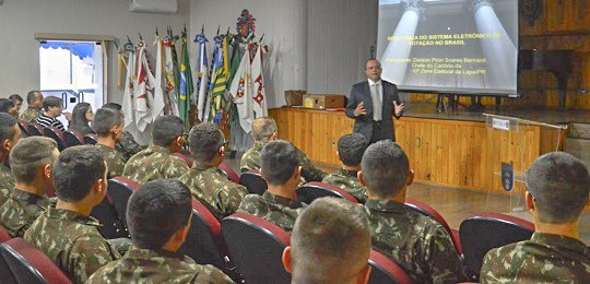 2019-09-25-lapa Imagem de um auditório cheio com militares sentados observando um homem realizando uma apresenta...