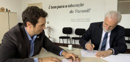 dois homens com caneta na mão assinando papéis
