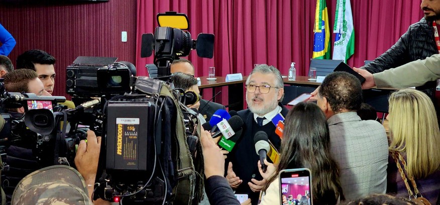 “Teremos a melhor eleição de todos os tempos”, afirma presidente do TRE-PR em coletiva com a imprensa fotografia de um homem de terno e gravata cercado por jornalistas, microfones e câmeras de telev...