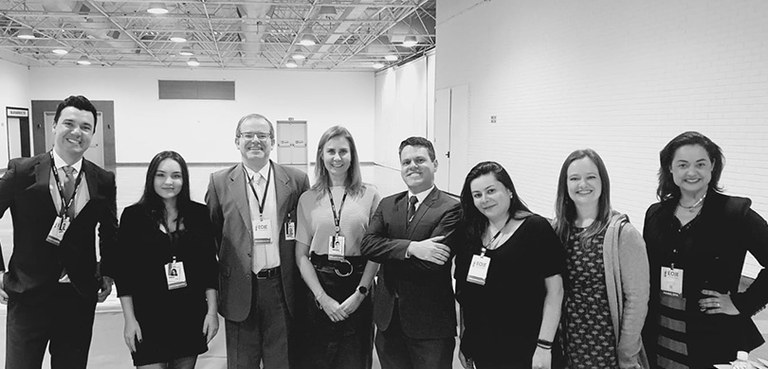 2023-05-23-eoje-comissão Fotografia em preto e branco de um grupo de pessoas posando para foto sorrindo. São cinco mulher...