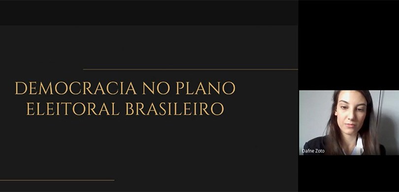 Foto de um print de tela durante uma videoconferência. É possível ver uma mulher com a câmera ab...