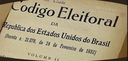 Fotografia da capa do Código Eleitoral brasileiro. O fundo é uma folha já amarelada, ao centro é...