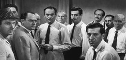 Fotografia, reproduzida de um filme em preto e branco, de vários homens de camisa branca e gravata