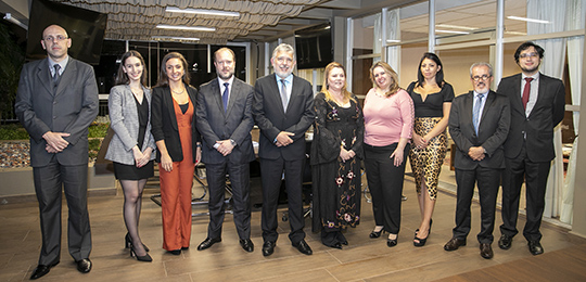 Autores de obra sobre crimes eleitorais Fotografia de um grupo de pessoas em pé, lado a lado, em uma sala de reuniões.