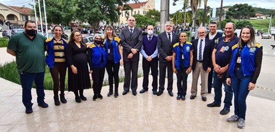 foto de um grupo de pessoas em pé, olhando para a câmera. Elas estão no pátio de uma escola 