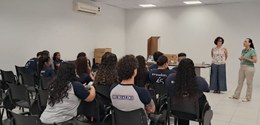 Fotografia que retrata uma atividade institucional em ambiente interno com aproximadamente quinz...