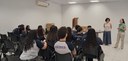 Fotografia que retrata uma atividade institucional em ambiente interno com aproximadamente quinz...