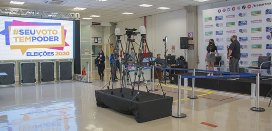 Centro de Divulgação das Eleições 2020 seguiu modelo inédito Foto do Centro de divulgação das Eleições 2020. À esquerda, há um telão, no centro há câmeras po...