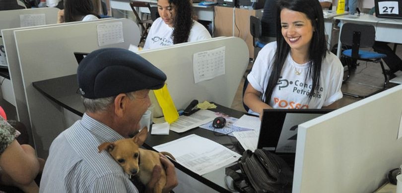 Fotografia na qual é possível ver um homem idoso, vestindo uma boina preta e uma camisa listrada...