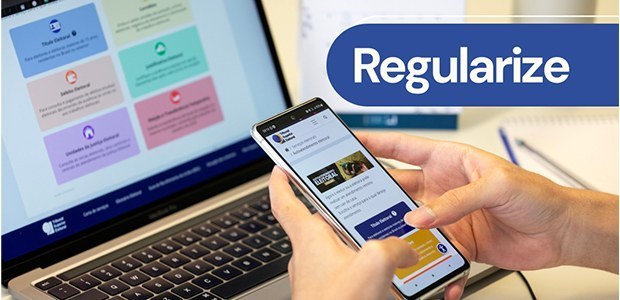 Conheça seis motivos para manter Título de Eleitor regularizado Fotografia que exibe a mão de uma pessoa segurando um celular do lado direito da imagem. A tela ...