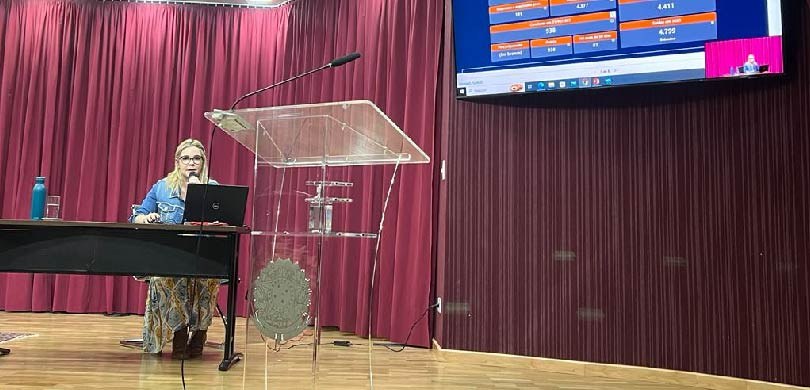 Corregedoria promove capacitação sobre Gestão Processual A foto mostra no fundo uma cortina vermelha e um painel com dados que são apresentados por uma m...