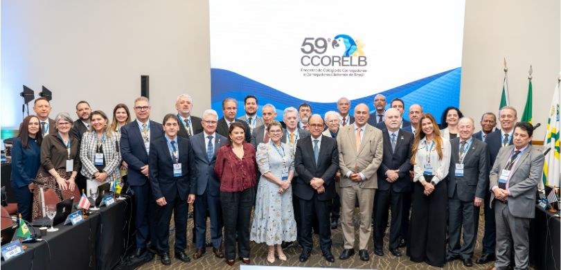 Fotografia em que se observa um grupo de aproximadamente 30 pessoas, entre homens e mulheres, po...