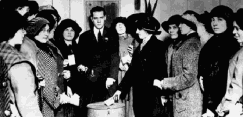 Fotografia em preto e branco que retrata um grupo de pessoas, majoritariamente mulheres, em um a...