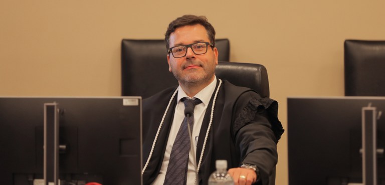 Fotografia de oito pessoas, sendo cinco homens e três mulheres, posicionadas lado a lado em pé p...