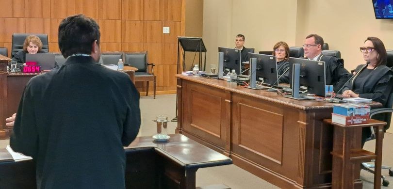 Fotografia em que se observa o lado direito da Corte do TRE-PR. Em primeiro plano, vê-se um advo...