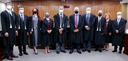 Dez pessoas, membros da Corte do TRE-PR, posando uma ao lado da outra para foto na sala de sessõ...