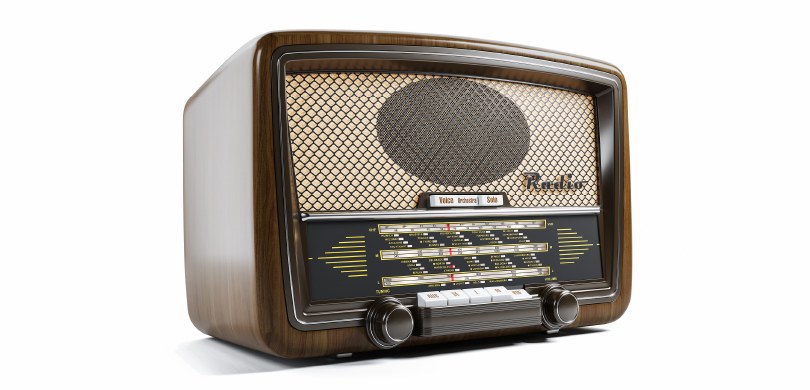 Dia do Rádio: a importância no processo eleitoral Foto de um aparelho de rádio antigo. É uma caixa retangular, em madeira, com botões e uma saída ...