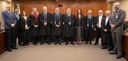 A imagem mostra a sala de sessões da Corte. Estão de pé posando para a foto nove homens e três m...