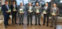 Fotografia de sete homens, vestindo ternos e gravatas, segurando a edição de abril da revista Pa...