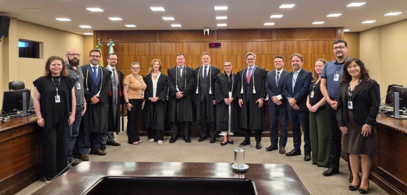 EJE-PR apresenta relatório de atividades de 2025 Na fotografia vê-se homens e mulheres posando sorrindo, uns ao lado dos outros. Nas laterais, ob...