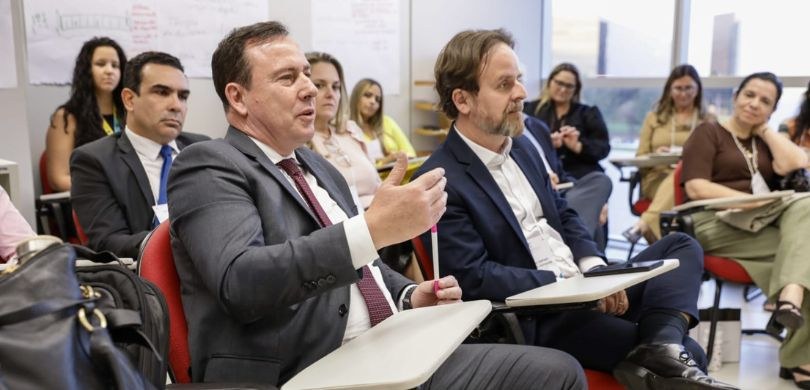 EJE-PR participa de Formação de Formadores no TSE Fotografia em que aparecem várias pessoas sentadas em carteiras com estofado vermelho em uma sal...