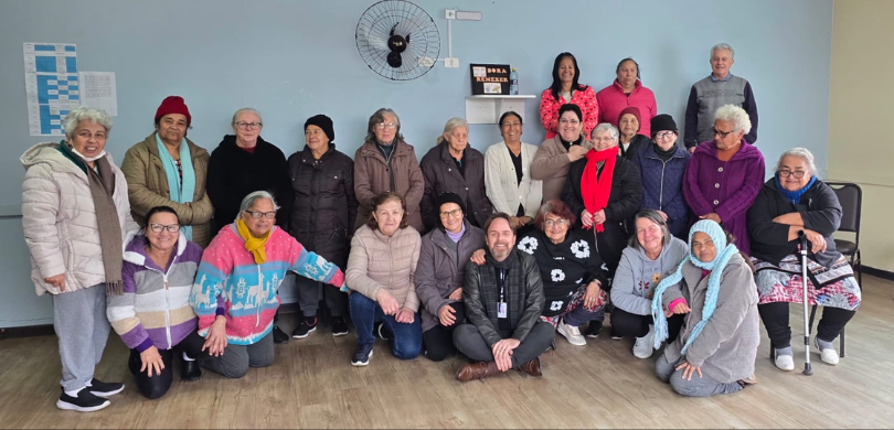 Fotografia de um grupo com cerca de 25 pessoas, majoritariamente mulheres idosas, posando juntas...