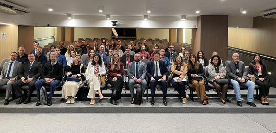 Fotografia de um grupo de aproximadamente quarenta pessoas, composto por homens e mulheres de di...