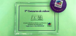 Banner em fundo verde, com um certificado transparente, escrito em roxo: 3° Concurso de Vídeos -...