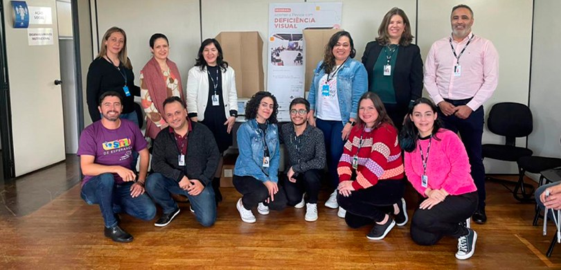 Fotografia de um grupo de doze pessoas, seis estão em pé e outras seis estão agachadas. Há homen...