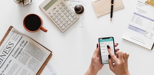 EJE/TSE realiza nesta quarta (17) webinário sobre prestação de contas e financiamento de campanhas Banner em fundo branco onde aparece uma mão segurando um celular e, à esquerda, uma calculadora