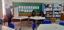 Fotografia que retrata uma simulação de votação em uma sala de aula. Em primeiro plano, observam...
