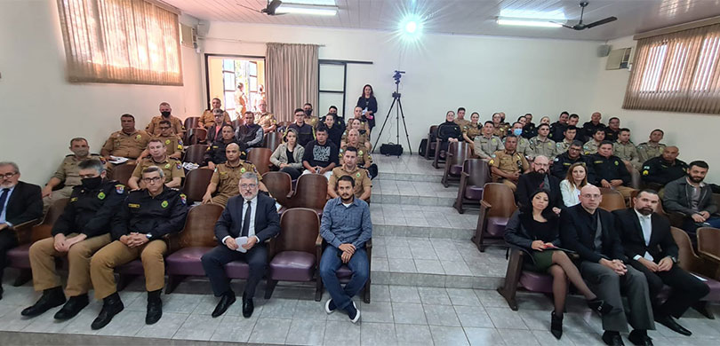 Fotografia de um auditório com a presença de autoridades e policiais militares.