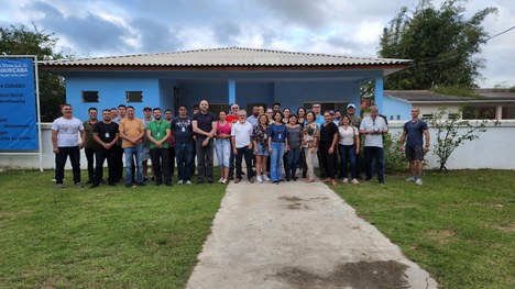 Fotografia de um grupo de indígenas sentados em uma central de atendimento ao eleitor.