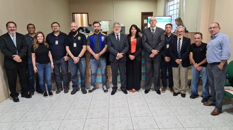 foto de um grupo de pessoas em pé, olhando para a câmera. Elas estão no pátio de uma escola 