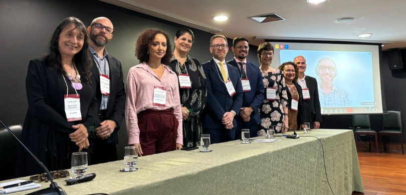 Fotografia na qual cinco mulheres e quatro homens posam sorrindo. Os participantes da apresentaç...