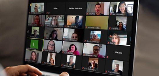 Fotografia de uma reunião por videoconferência com vários participantes.