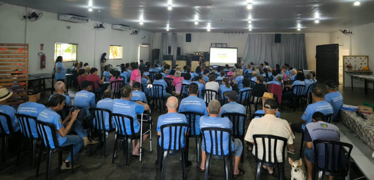 Fotografia de cinco pessoas, quatro homens e uma mulher, em uma sala clara. Dois rapazes com col...