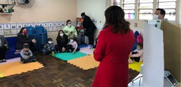 Foto de crianças e adultos em uma sala de aula