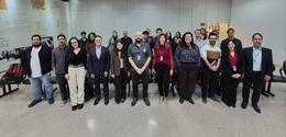 Fotografia de um grupo de aproximadamente vinte e cinco pessoas, entre homens e mulheres, posici...