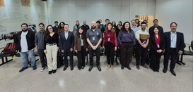 Fotografia de um grupo de aproximadamente vinte e cinco pessoas, entre homens e mulheres, posici...