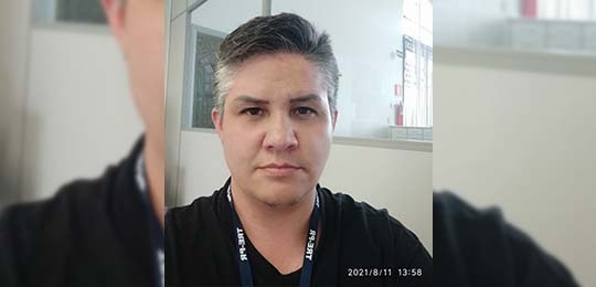 Eu me chamo JOHN! Fotografia de uma pessoa com roupa preta com cabelos grisalhos e o crachá do TRE-PR