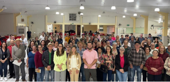 Fotografia de cinco pessoas, quatro homens e uma mulher, em uma sala clara. Dois rapazes com col...