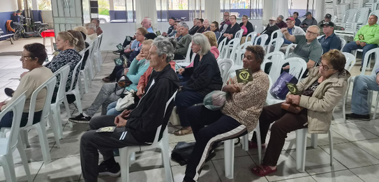 Fotografia de cinco pessoas, quatro homens e uma mulher, em uma sala clara. Dois rapazes com col...