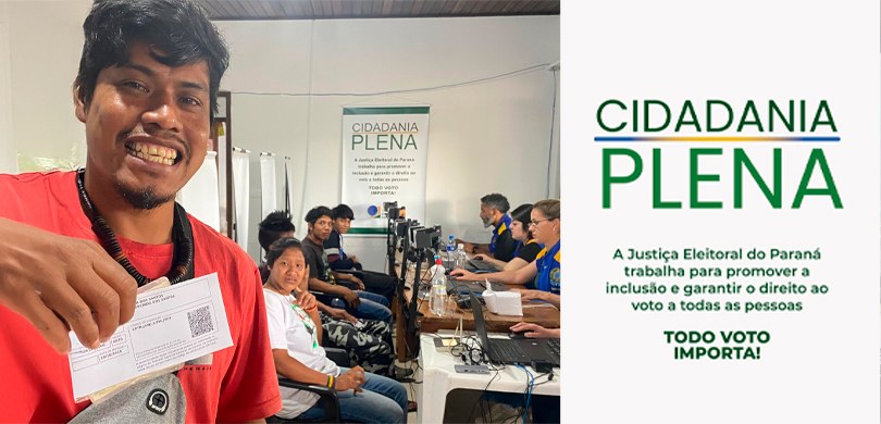 Fotografia de um eleitor indígena segurando seu Título Eleitoral enquanto sorri para a câmera. A...