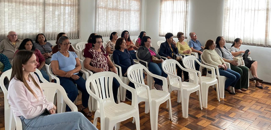 Fotografia de cinco pessoas, quatro homens e uma mulher, em uma sala clara. Dois rapazes com col...