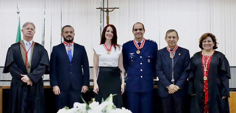 Fotografia de seis pessoas, duas mulheres e quatro homens, posando sorrindo para foto. Todos ves...