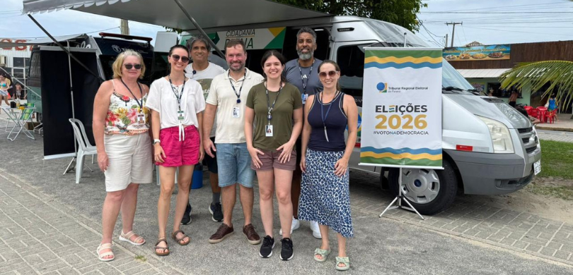 Fotografia em que se observa um grupo de sete pessoas, composto por quatro mulheres e três homen...