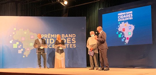 Justiça Eleitoral do Paraná participa da entrega do Prêmio Cidades Excelentes Foto de quatro pessoas em um palco. À esquerda, um homem e uma mulher em pé atrás de dois púlpit...